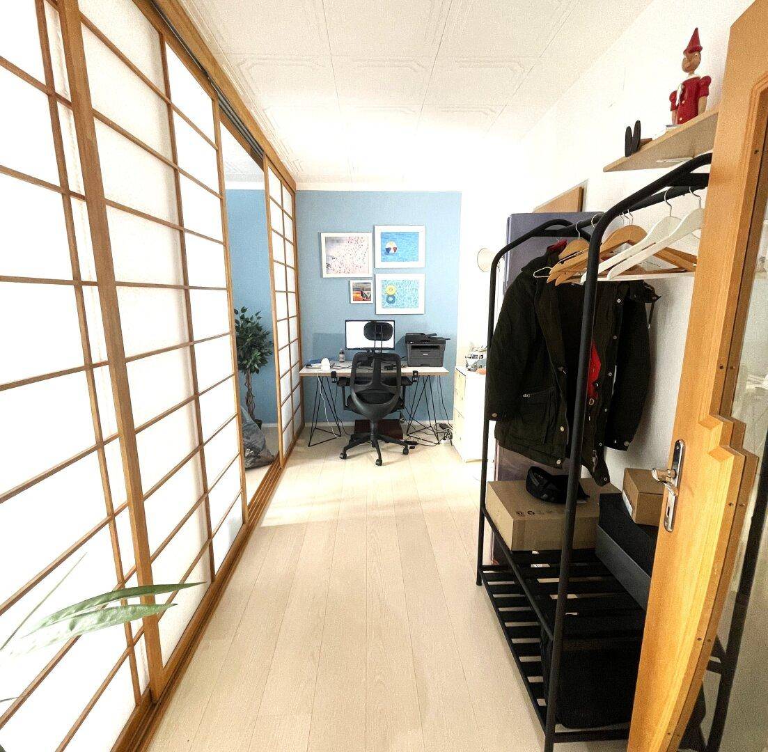 Heller Flur mit Schiebetüren im japanischen Stil und einem kleinen Arbeitsbereich am Ende.