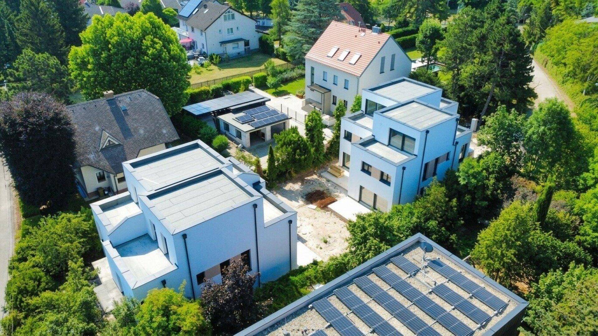 Luftaufnahme einer modernen Wohnsiedlung mit mehreren Neubauten und viel Grünfläche.