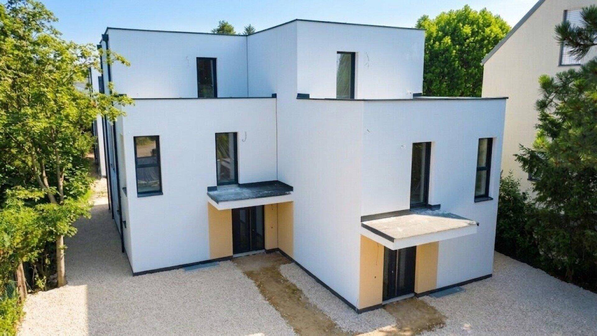 Moderne Doppelhaushälfte mit minimalistischer Architektur und einladendem Eingangsbereich.