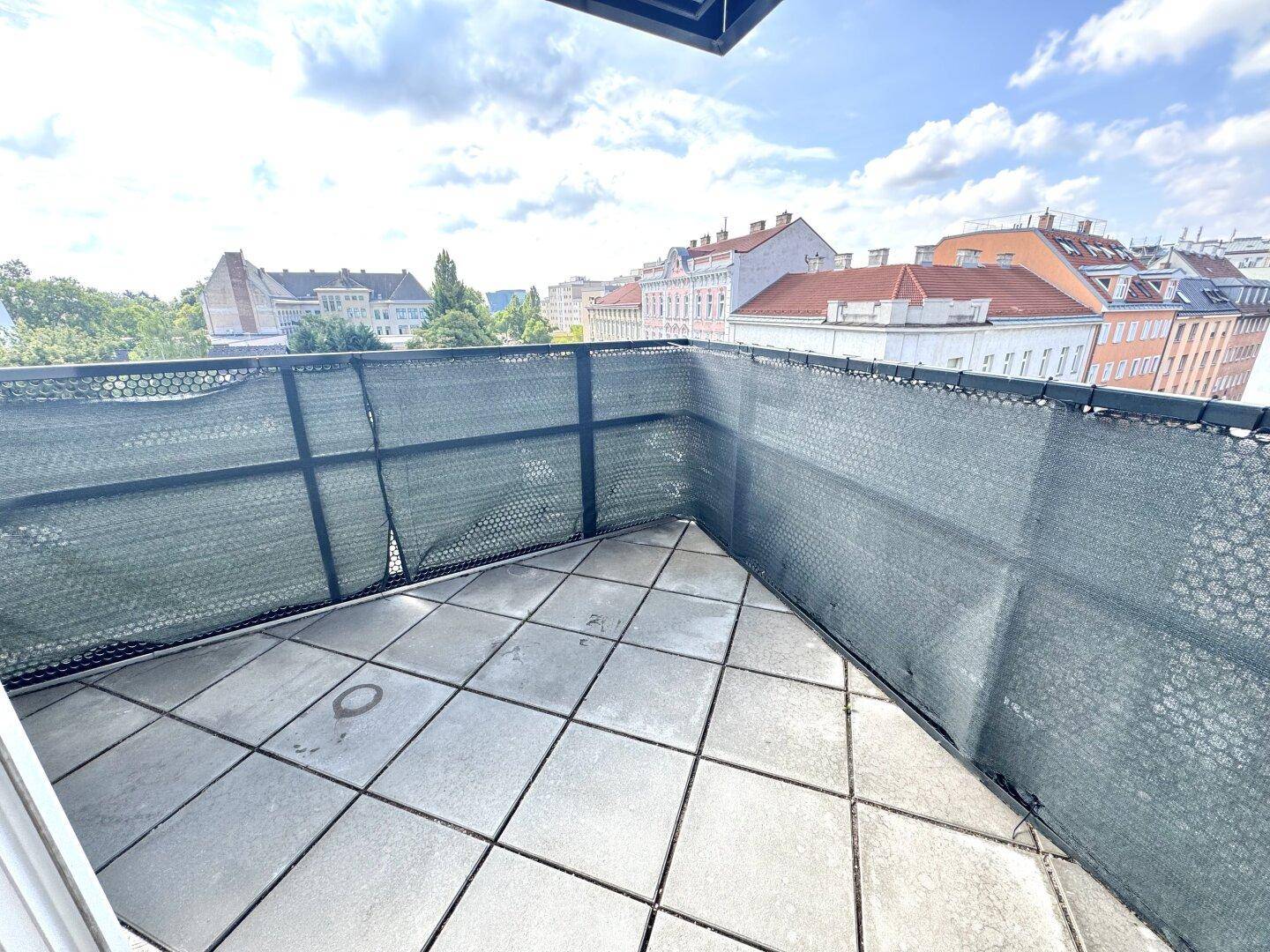Kleiner Balkon mit Fliesenboden und Sichtschutz, ideal für entspannte Stunden im Freien.