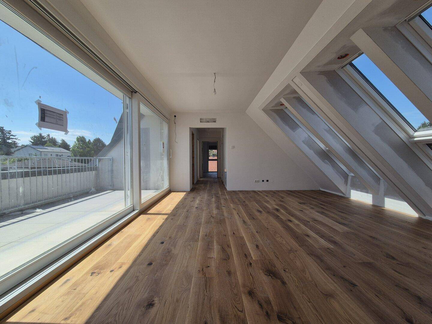 Heller Wohnbereich mit Holzboden, großen Schiebetüren und direktem Zugang zu einer sonnigen Terrasse.