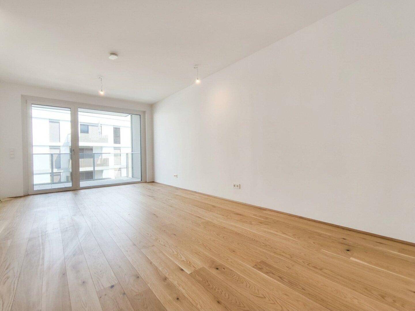 Geräumiges, helles Zimmer mit neuem Holzparkett und großen Fenstern, bereit zur individuellen Gestaltung.