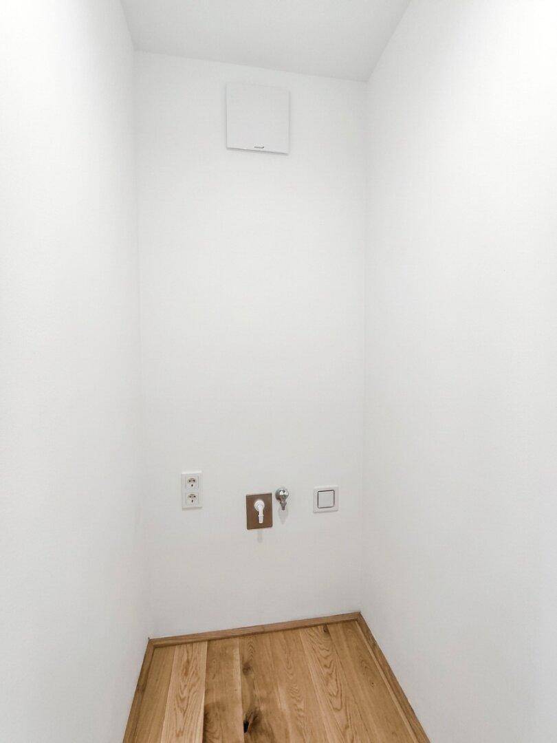 Kleiner Hauswirtschaftsraum mit Eichenparkett und Anschlüssen für Geräte.