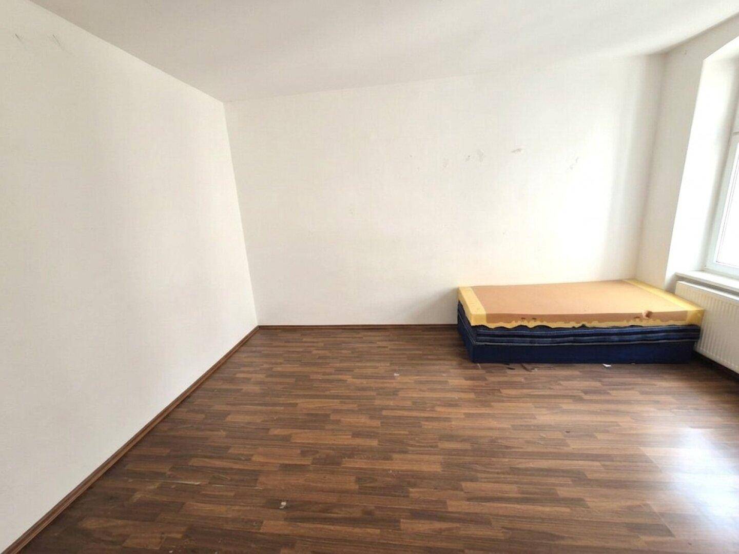 Geräumiges Schlafzimmer mit Laminatboden und hellen Wänden, ideal für persönliche Einrichtungsideen.