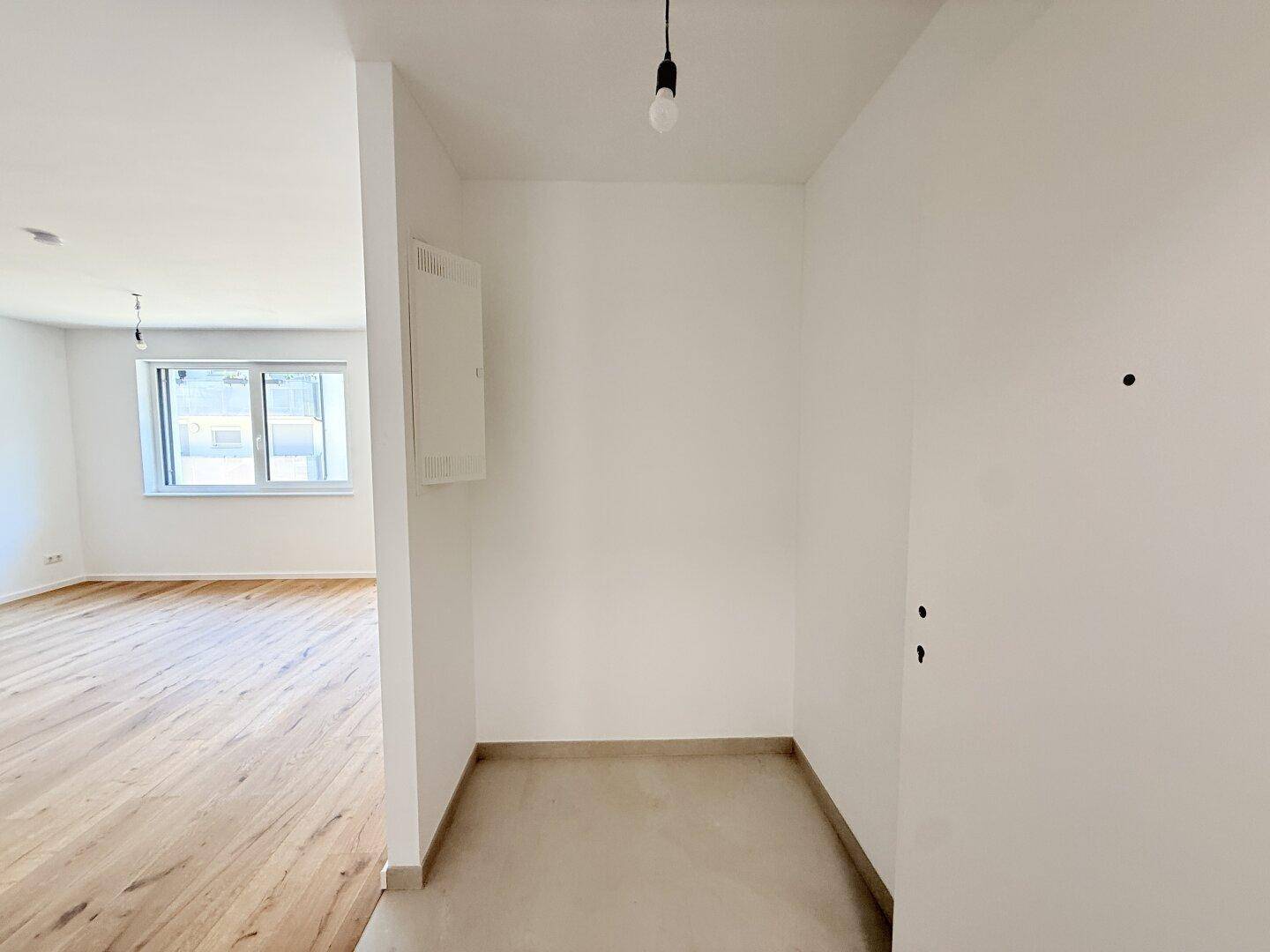 Heller Eingangsbereich mit Fliesenboden und Zugang zu weiteren Räumen der Wohnung.