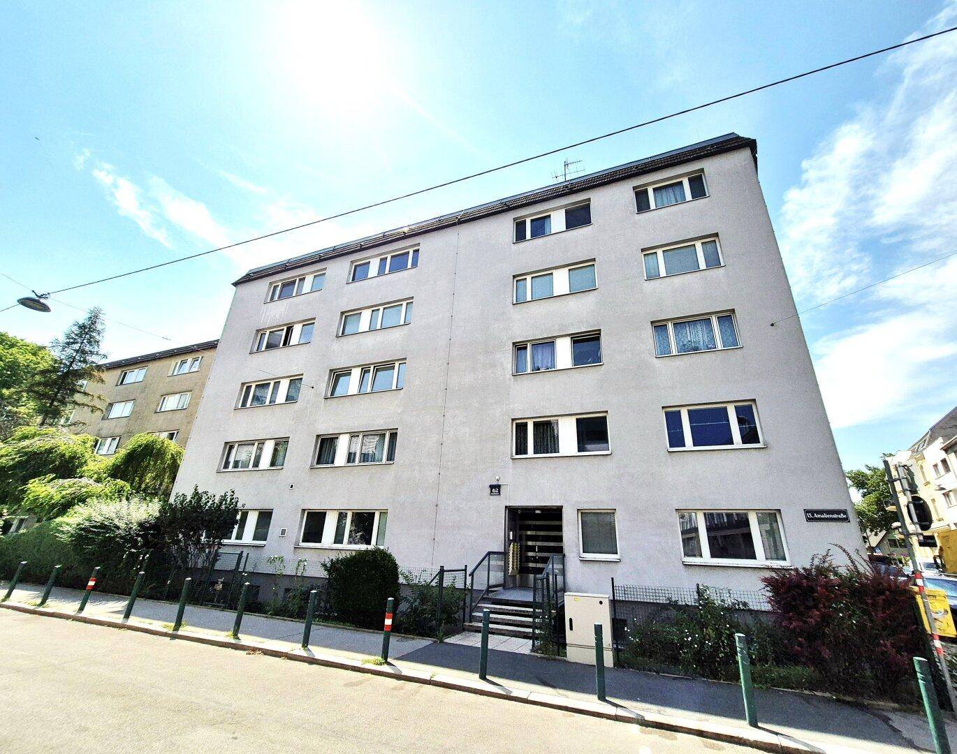 Mehrstöckiges Wohngebäude mit vielen Fenstern und einer schlichten, grauen Fassade.