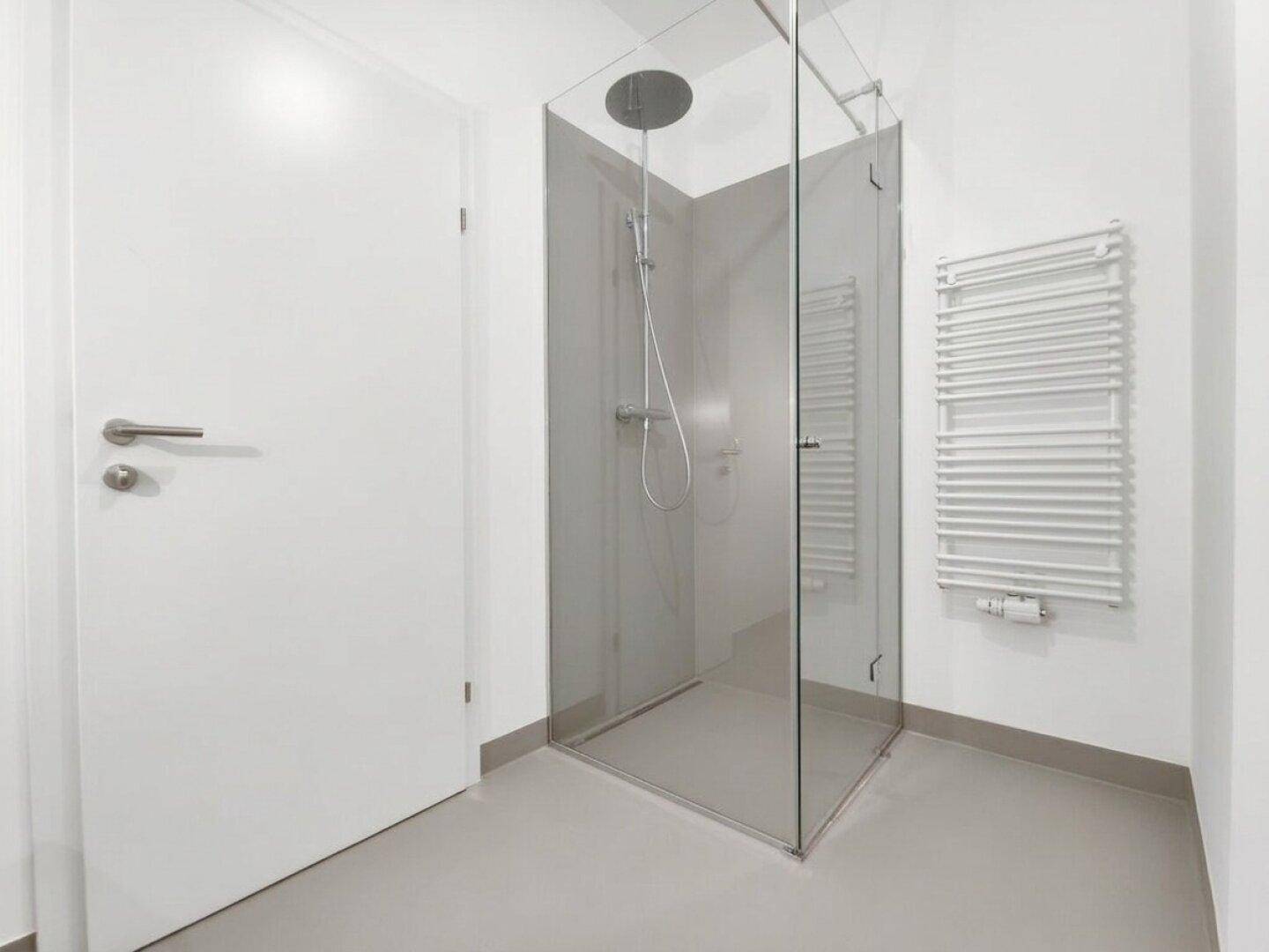 Modernes Badezimmer mit ebenerdiger Dusche und beheiztem Handtuchhalter.