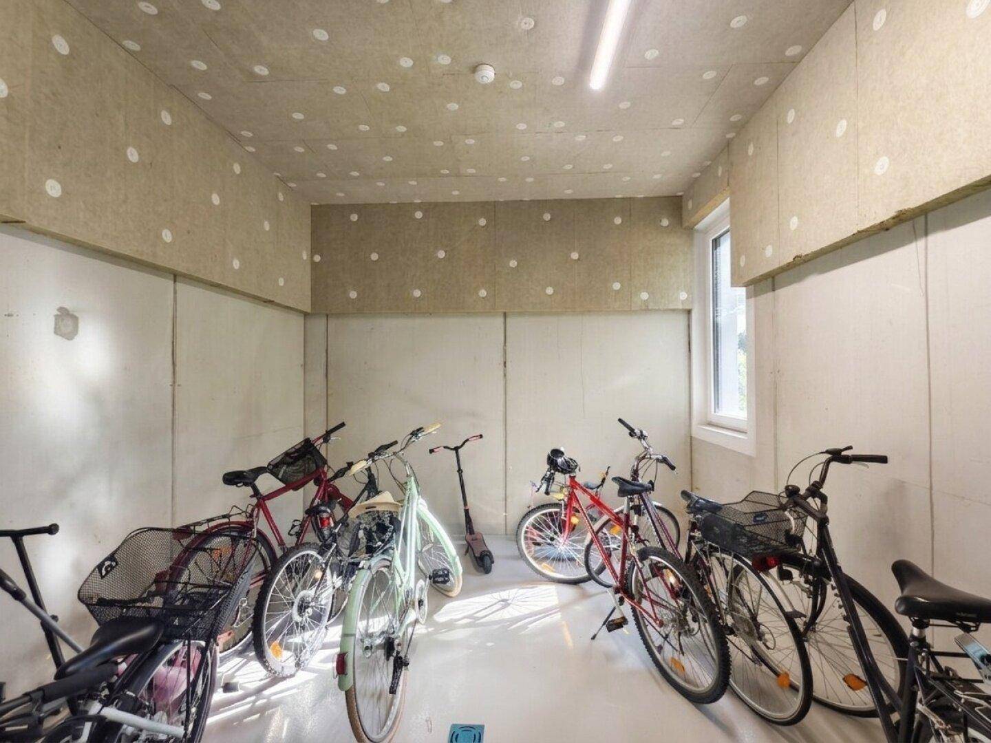 Geräumiger Fahrradraum mit mehreren Fahrrädern und einem Fenster für natürliche Belüftung.