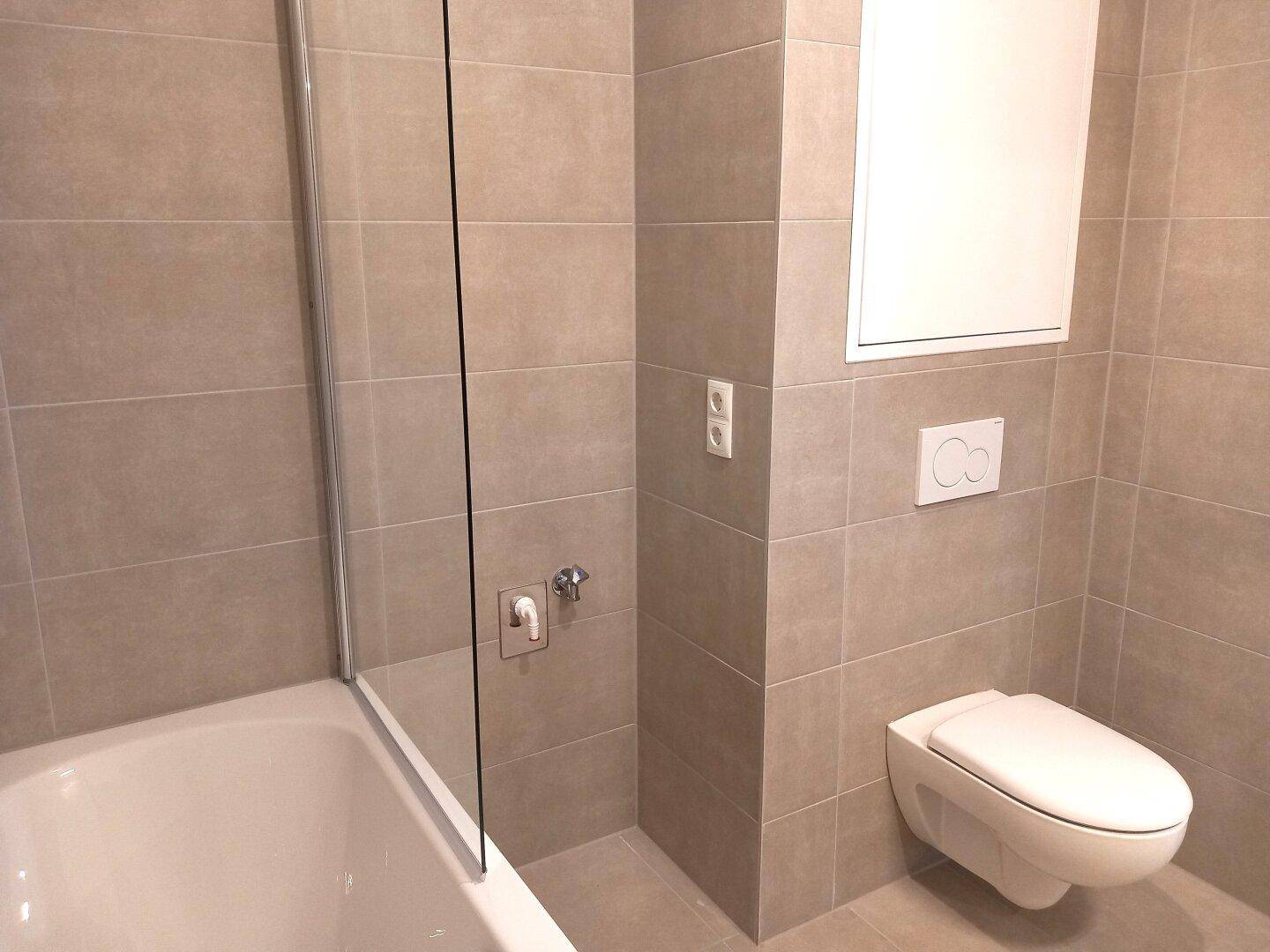 Modernes WC mit Wandtoilette und Fliesenboden, sauber und funktional gestaltet.