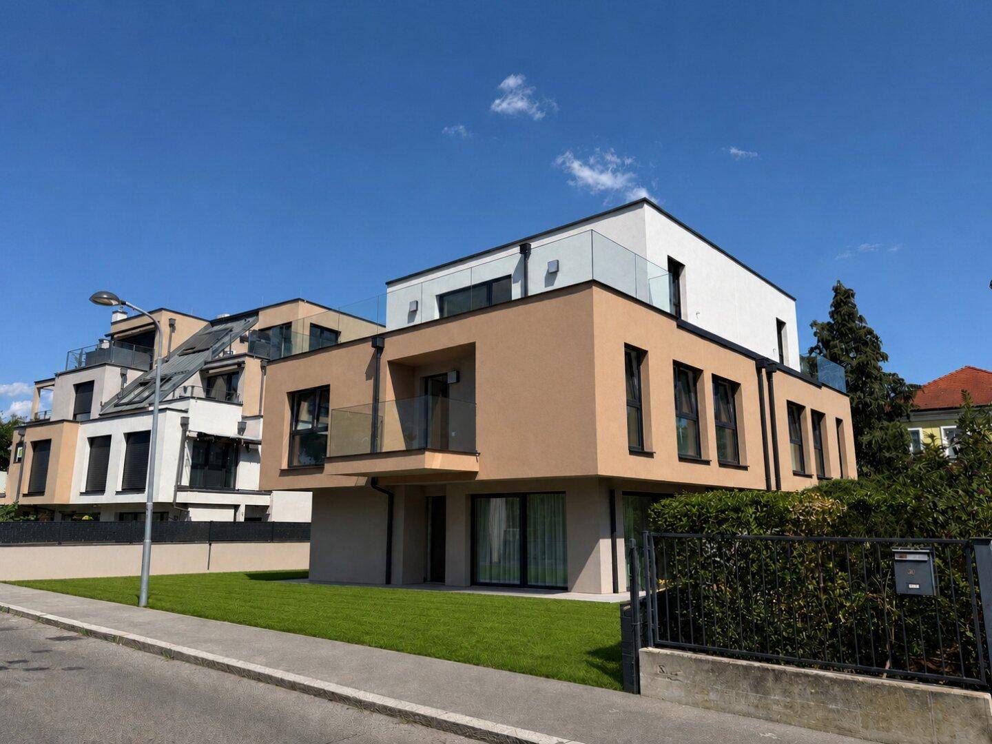 Zeitgenössisches Wohngebäude mit klarer Linienführung und Balkonen unter blauem Himmel.