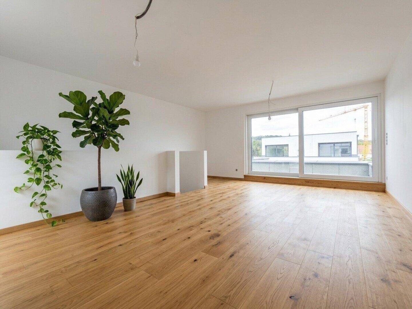 Geräumiger, heller Raum mit Holzboden und großen Schiebefenstern, ideal für individuelle Gestaltung.
