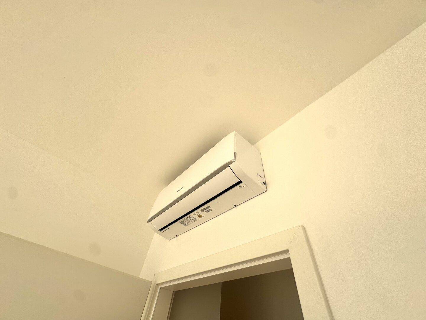 Detailaufnahme einer modernen Klimaanlage an der Wand, sorgt für angenehme Raumtemperatur.