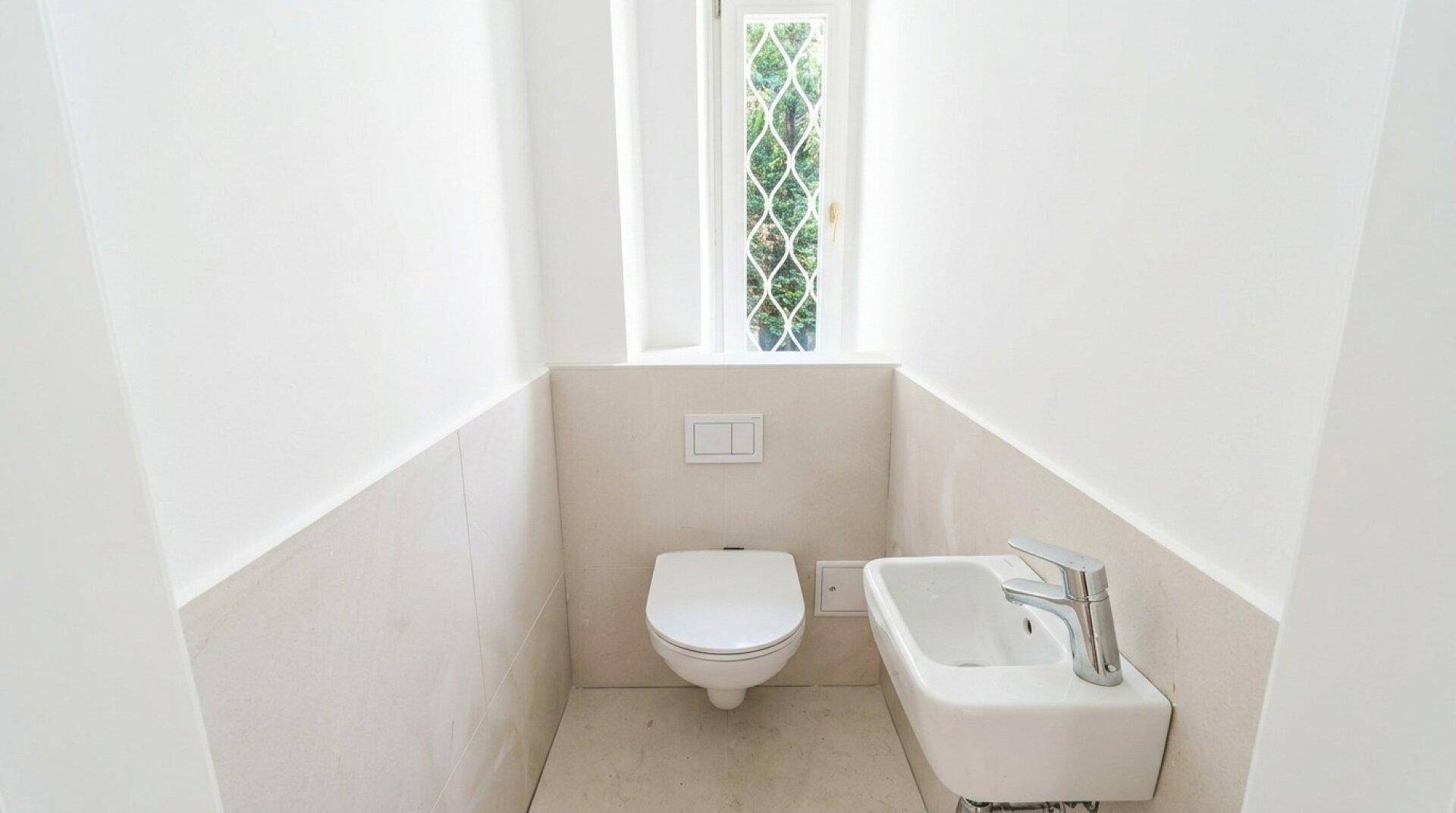 Modernes Gäste-WC mit wandhängendem WC, kleinem Waschbecken und Fenster.