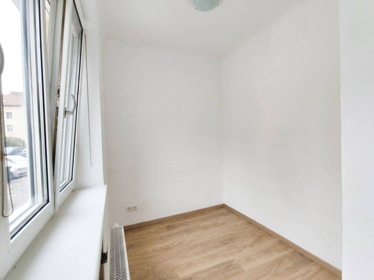 Kleiner, heller Raum mit Fenster und Laminatboden, ideal als Büro oder Abstellkammer nutzbar.