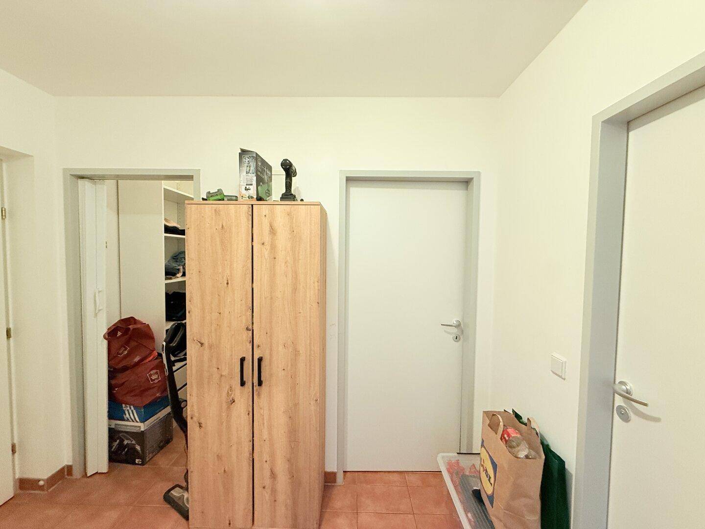 Flur mit Fliesenboden und Zugang zu einem begehbaren Kleiderschrank.