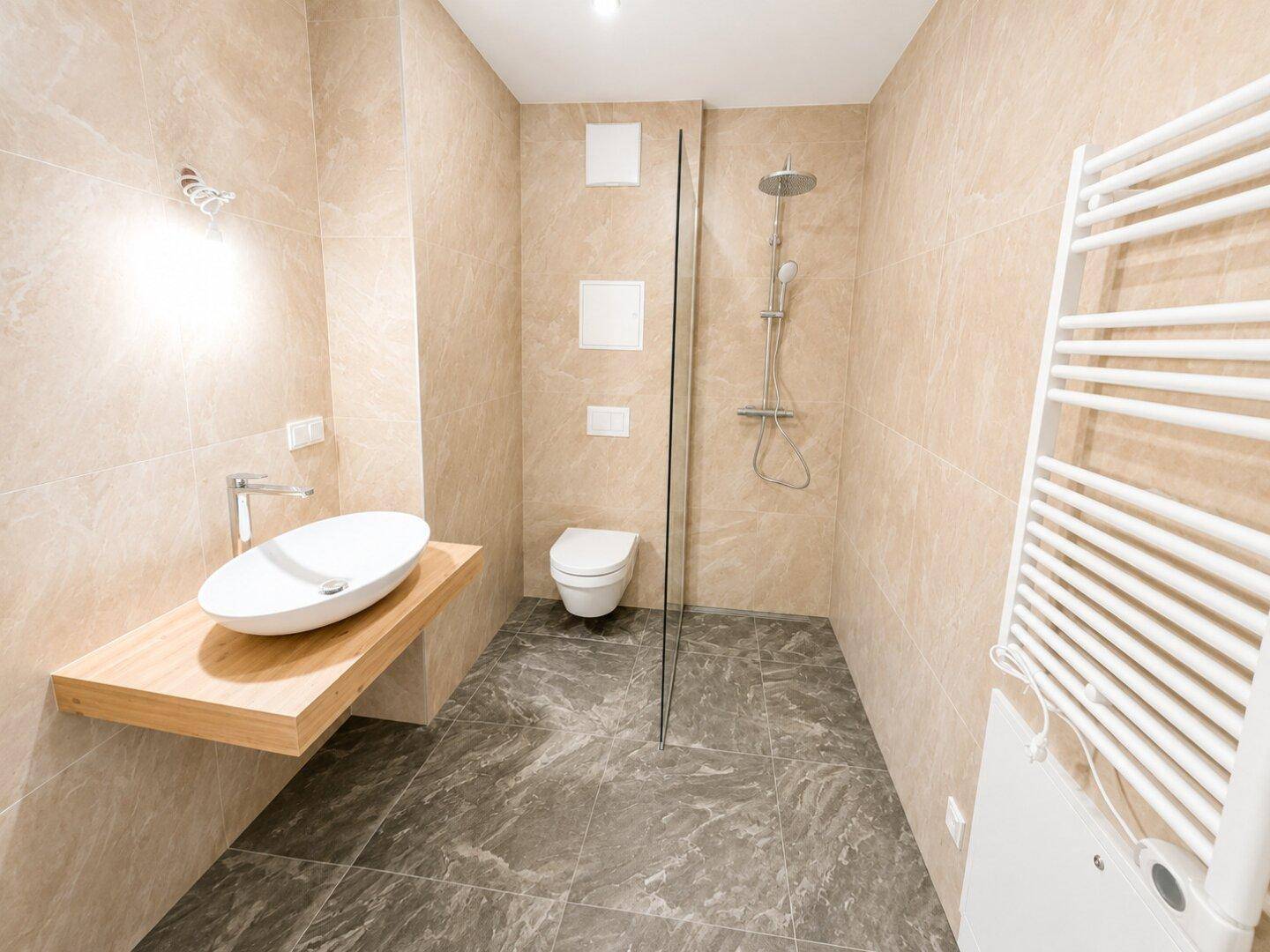 Modernes Badezimmer mit beigefarbenen Fliesen, ebenerdiger Dusche und Handtuchheizkörper.