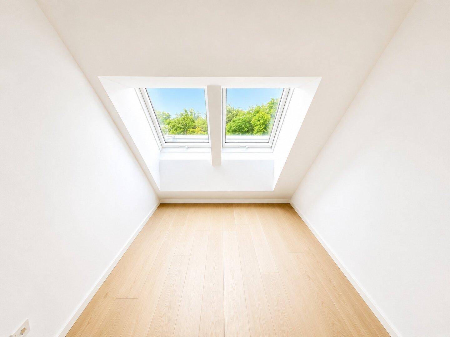 Lichtdurchfluteter Dachgeschossraum mit Holzboden und zwei großen Dachfenstern, bereit zum Einzug.