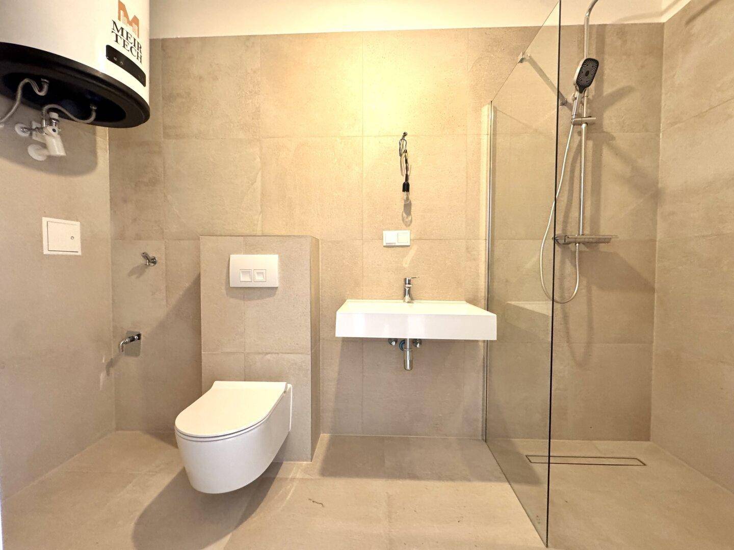 Modernes Badezimmer mit begehbarer Dusche, wandhängendem WC und stilvollem Einzelwaschbecken.
