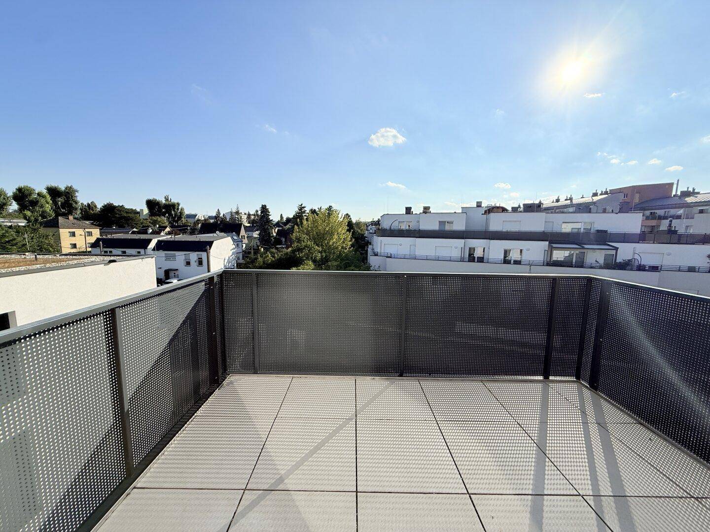 Sonniger Balkon mit Weitblick über die Dächer der Stadt und viel Platz im Freien.