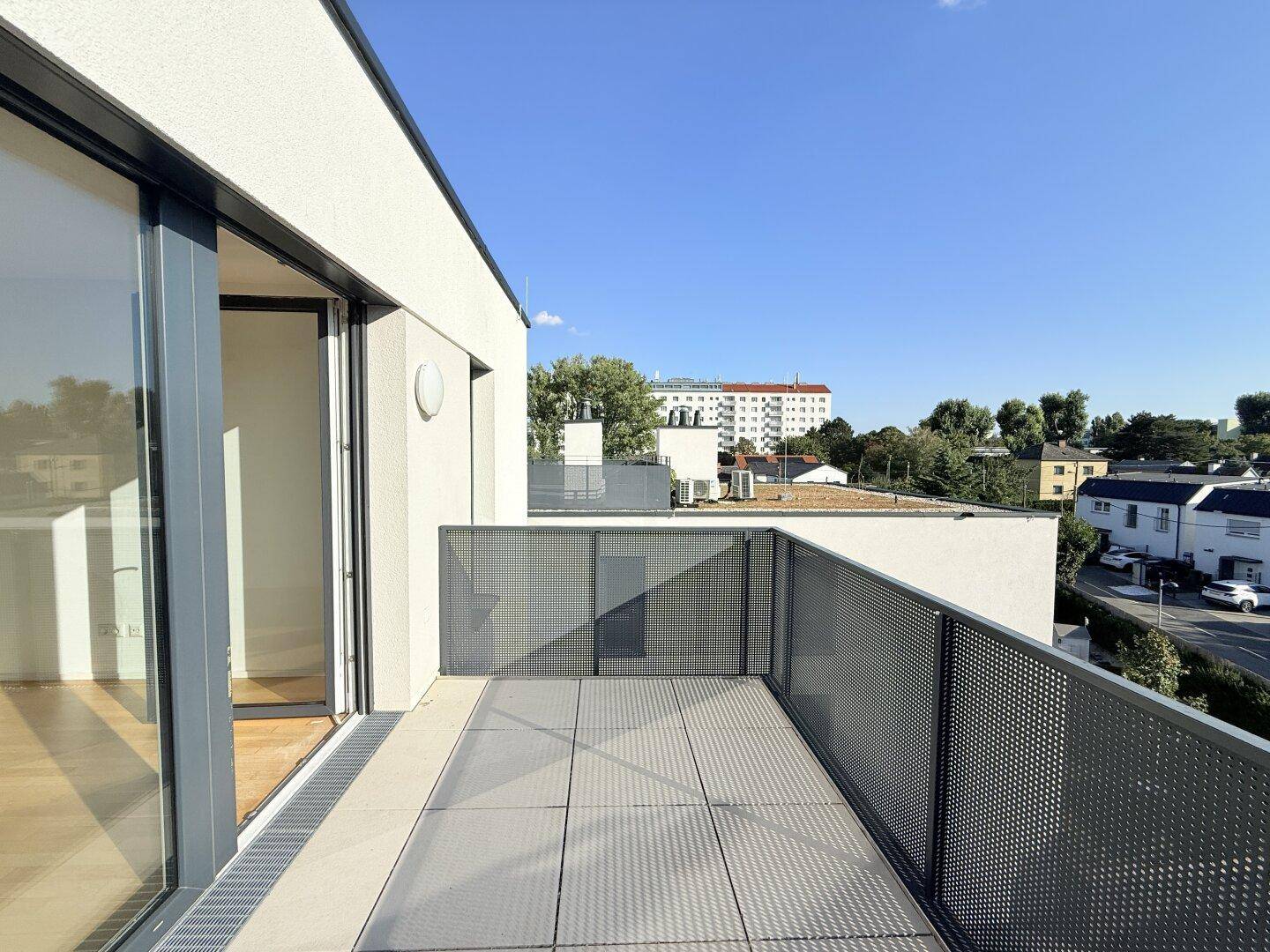 Geräumiger Balkon mit moderner Metallbrüstung und Blick auf die Umgebung.