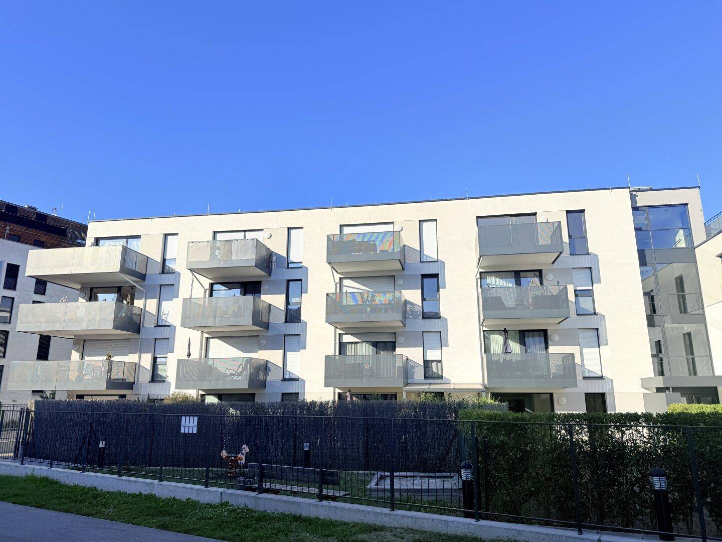 Ansicht eines modernen Mehrfamilienhauses mit klaren Linien und vielen Balkonen.