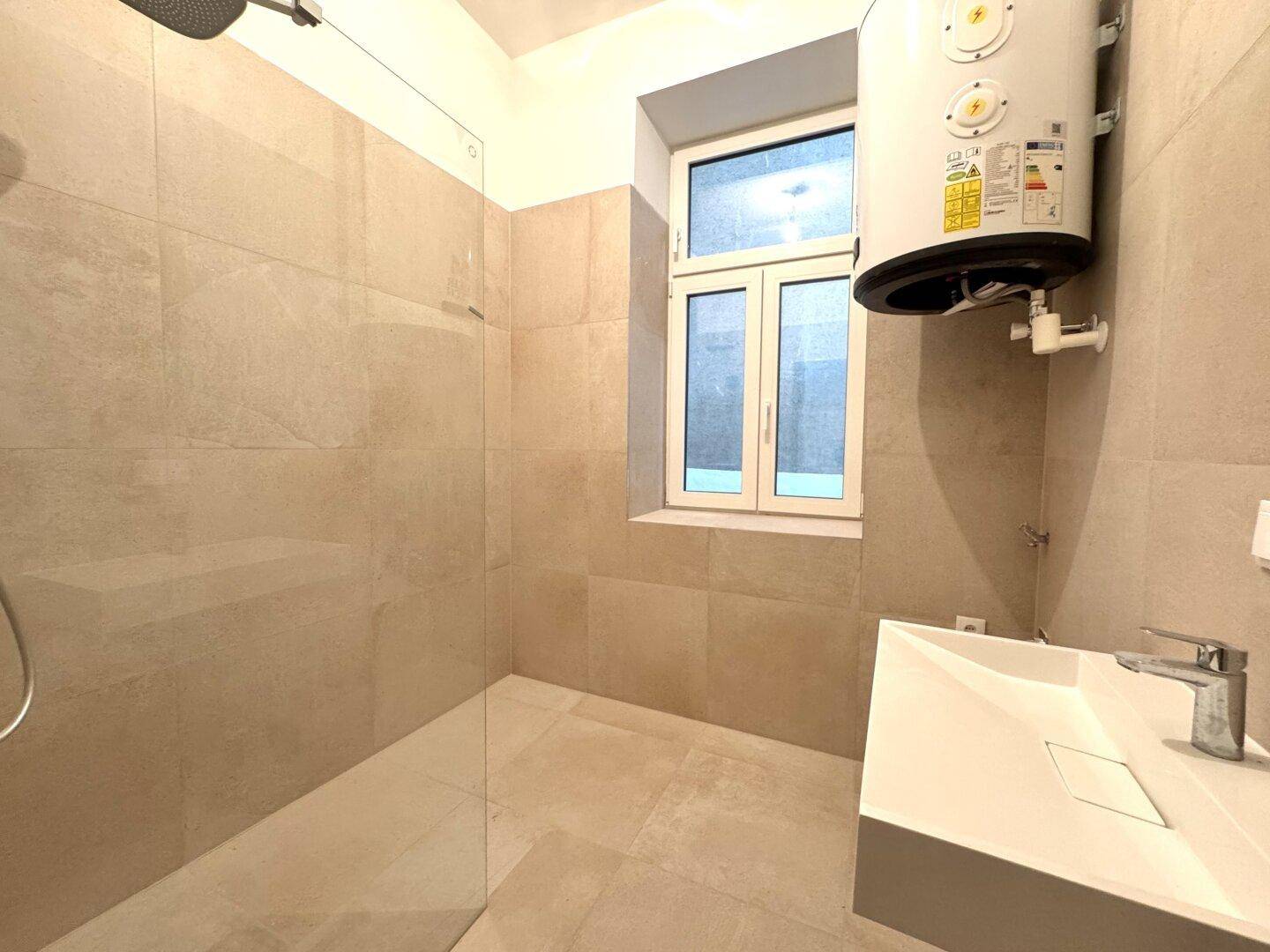 Modernes Badezimmer mit begehbarer Dusche, Waschbecken und Warmwasserboiler.