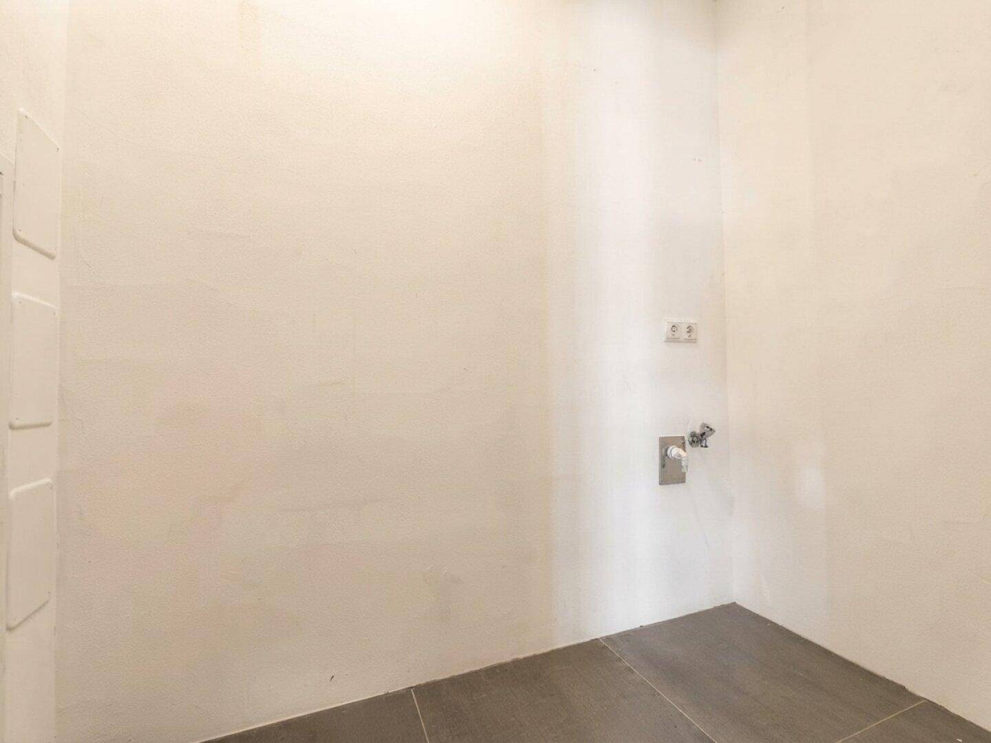 Praktischer Hauswirtschaftsraum mit Fliesenboden und Anschlüssen für Waschmaschine und Trockner.