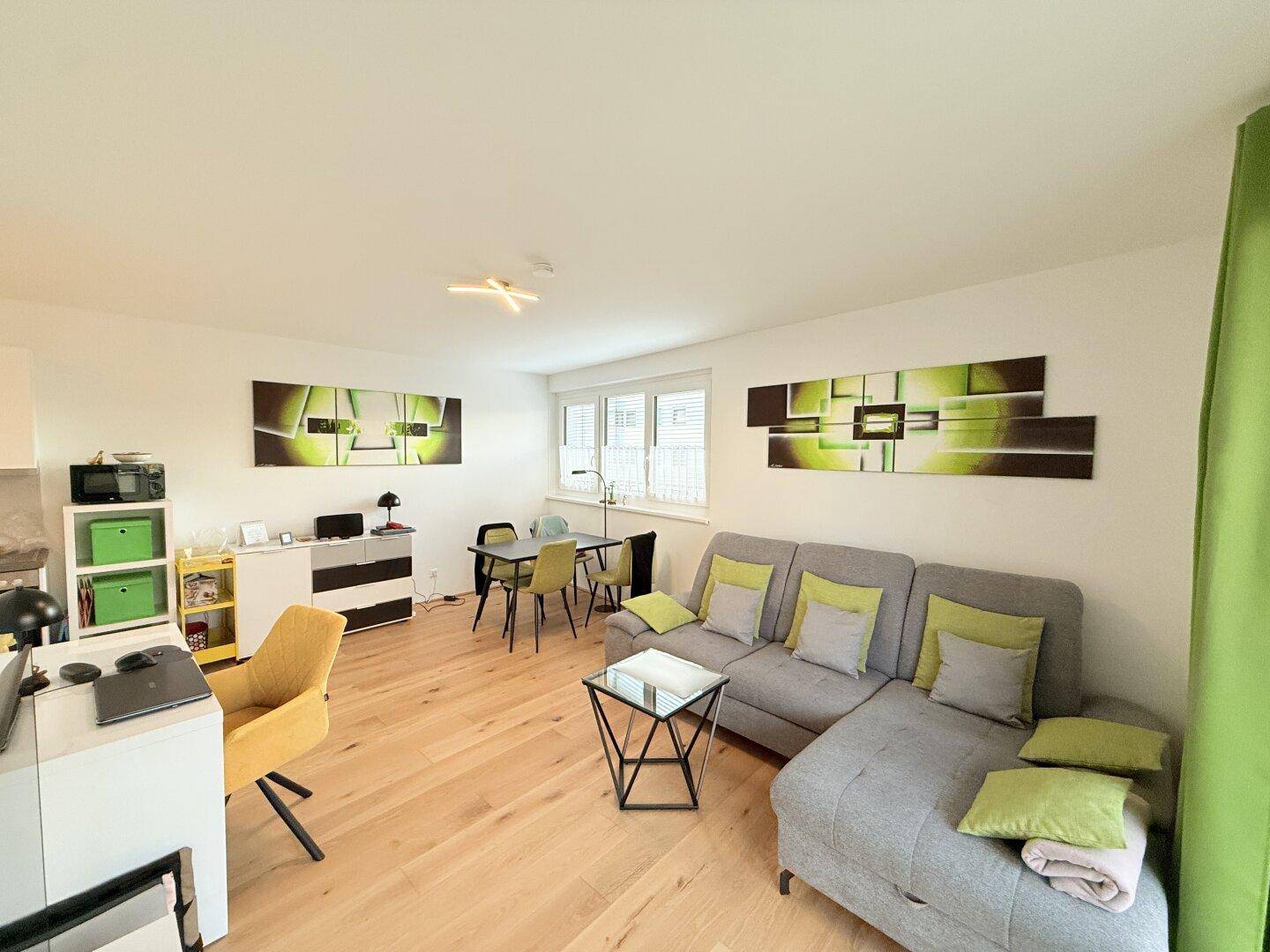 Geräumiges Wohn-Esszimmer mit bequemer Couch, Esstisch und modernem Dekor.