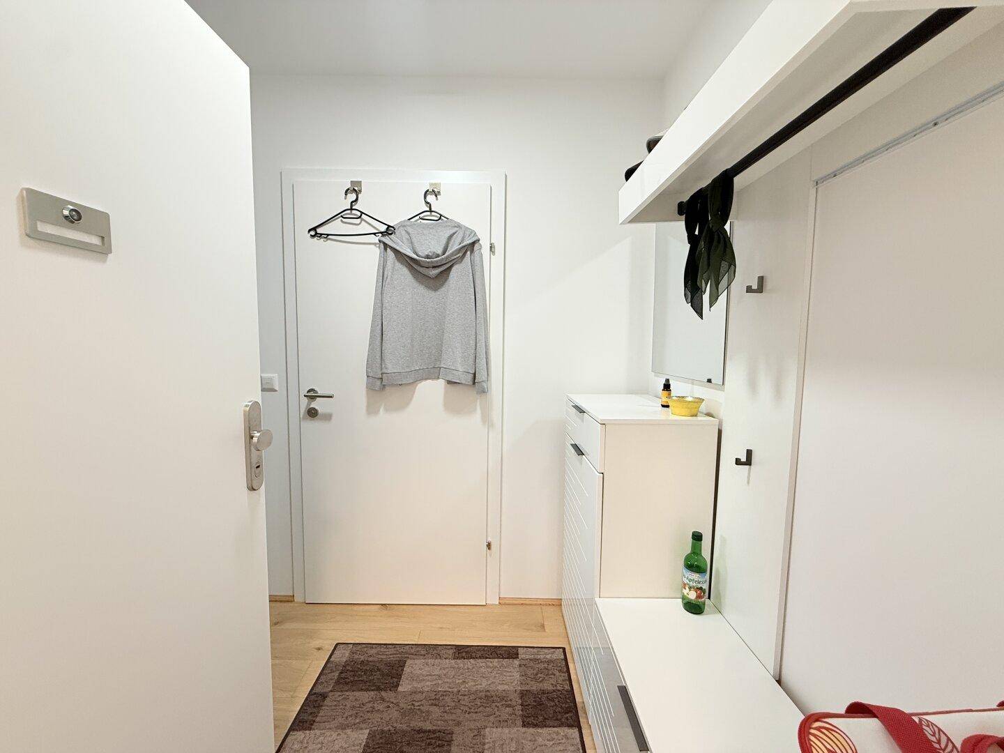 Eingangsbereich mit Garderobe, Schuhschrank und Spiegel.