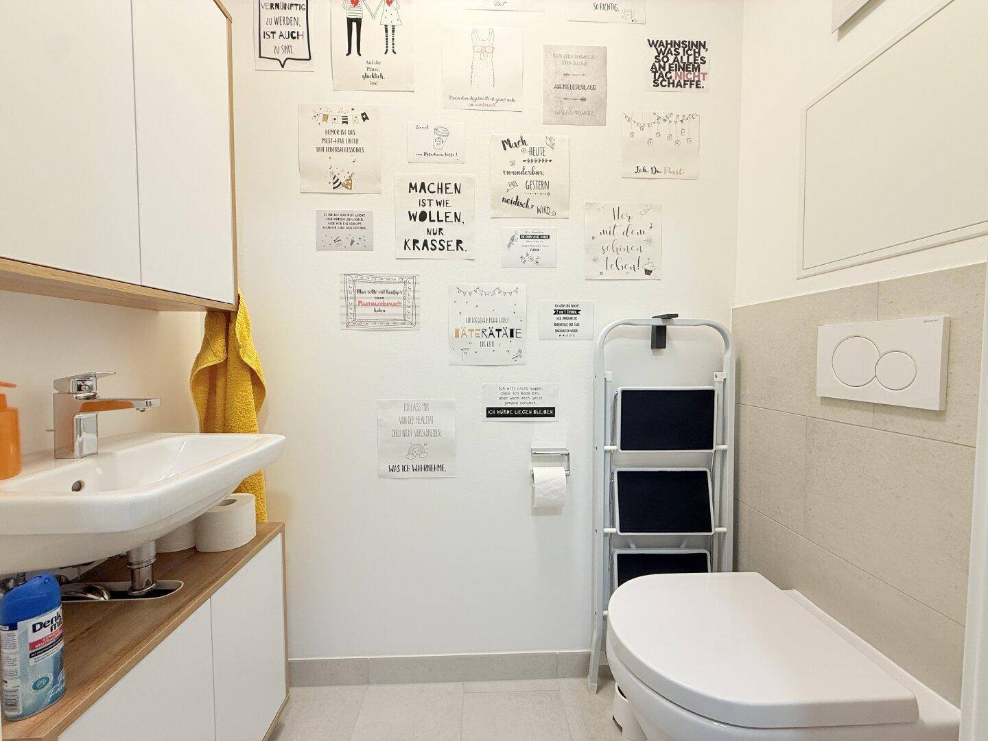 Modernes Gäste-WC mit Waschbecken, Toilette und kreativer Wandgestaltung.