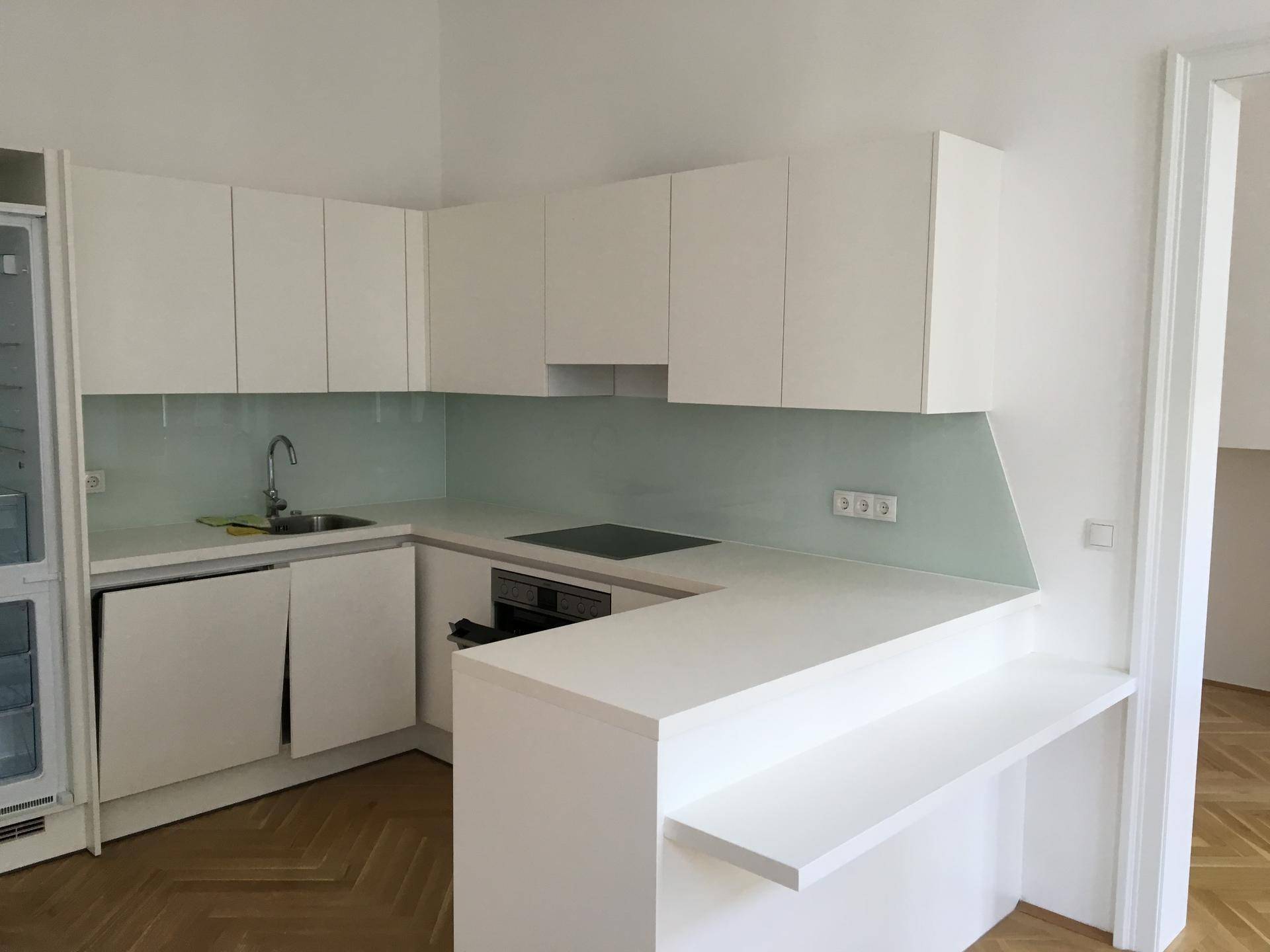 Helle Einbauküche in Weiß mit integriertem Geschirrspüler und Kühlschrank, ideal für modernes Wohnen.