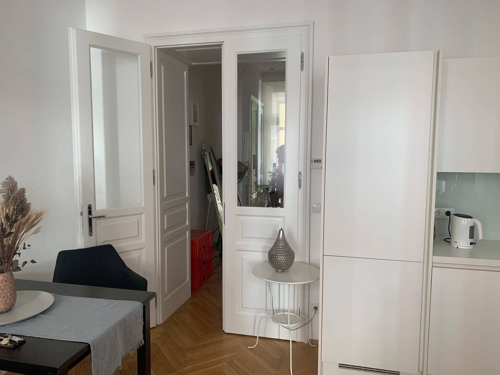 Elegante Doppeltüren mit Glaseinsätzen, die den Übergang zu einem weiteren Raum im Wohnbereich markieren.