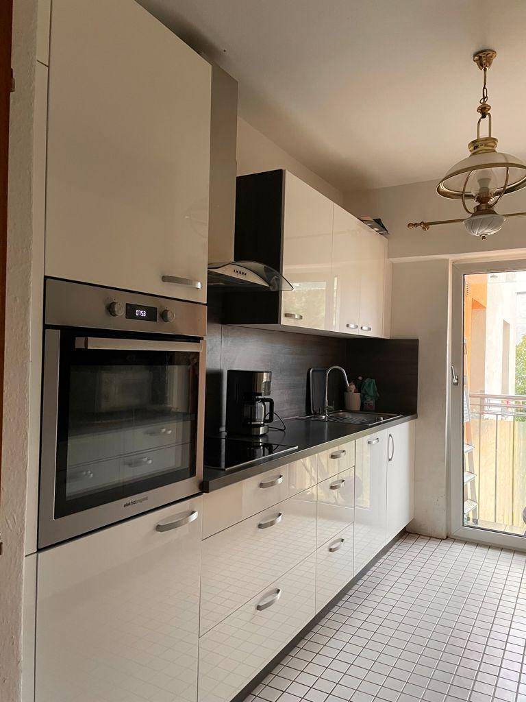 Moderne Küche mit integriertem Backofen, Induktionskochfeld und Dunstabzugshaube.