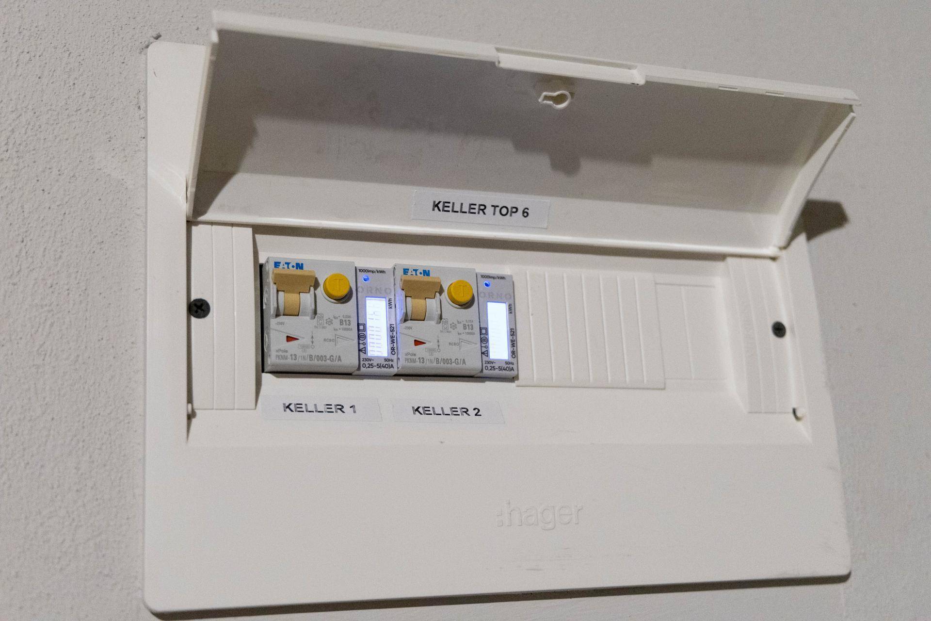 Moderner Sicherungskasten von Hager mit Beschriftungen für Kellerabteile, der die elektrische Versorgung regelt.