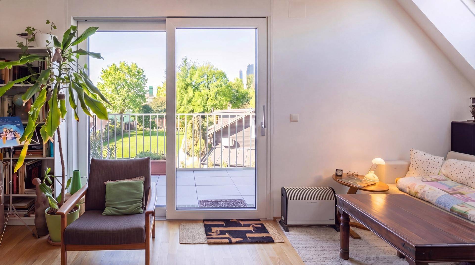 Helles Wohnzimmer mit Zugang zu einer großen Terrasse und Blick ins Grüne.