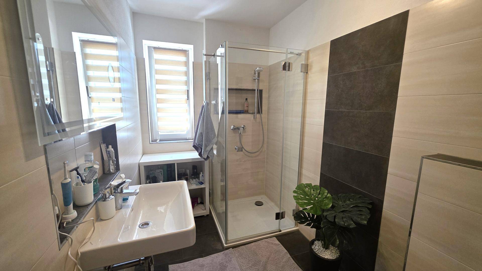 Modernes Badezimmer mit ebenerdiger Dusche, Einzelwaschbecken und Fenster.