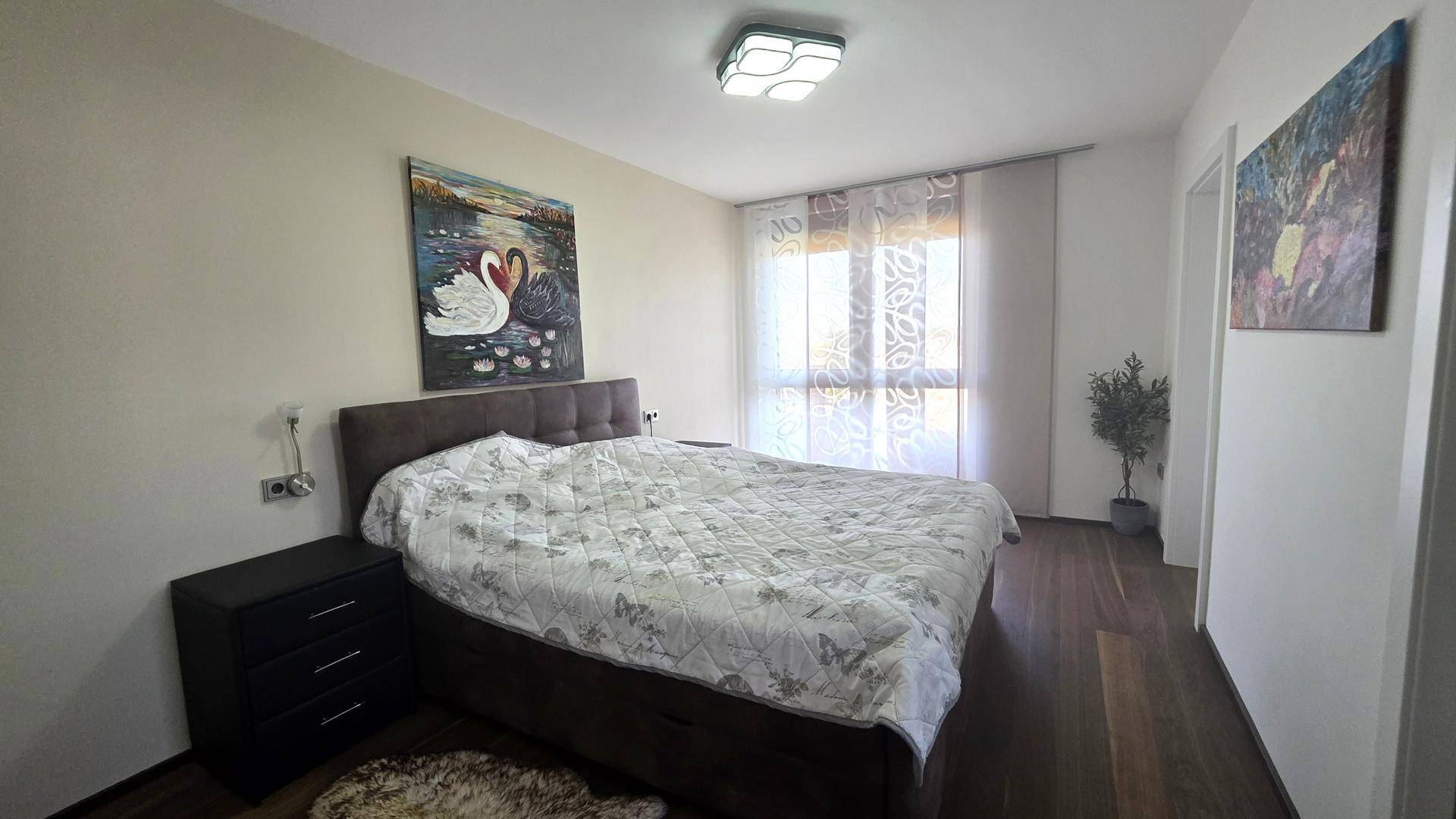 Geräumiges Schlafzimmer mit Doppelbett, Nachttischen und großen Fenstern.