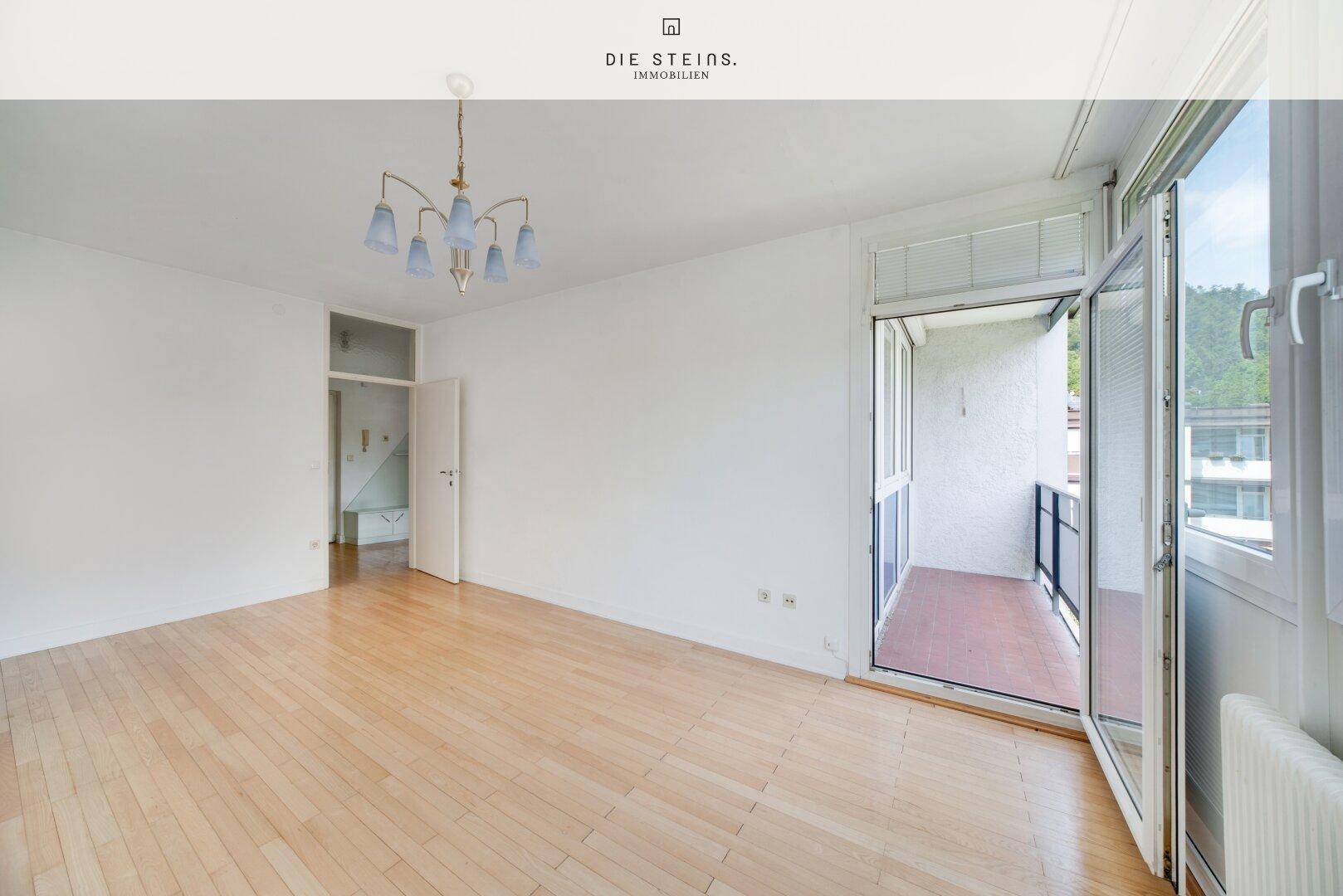 Helles Wohnzimmer mit Parkettboden und direktem Zugang zu einem Balkon, bereit zur individuellen Gestaltung.