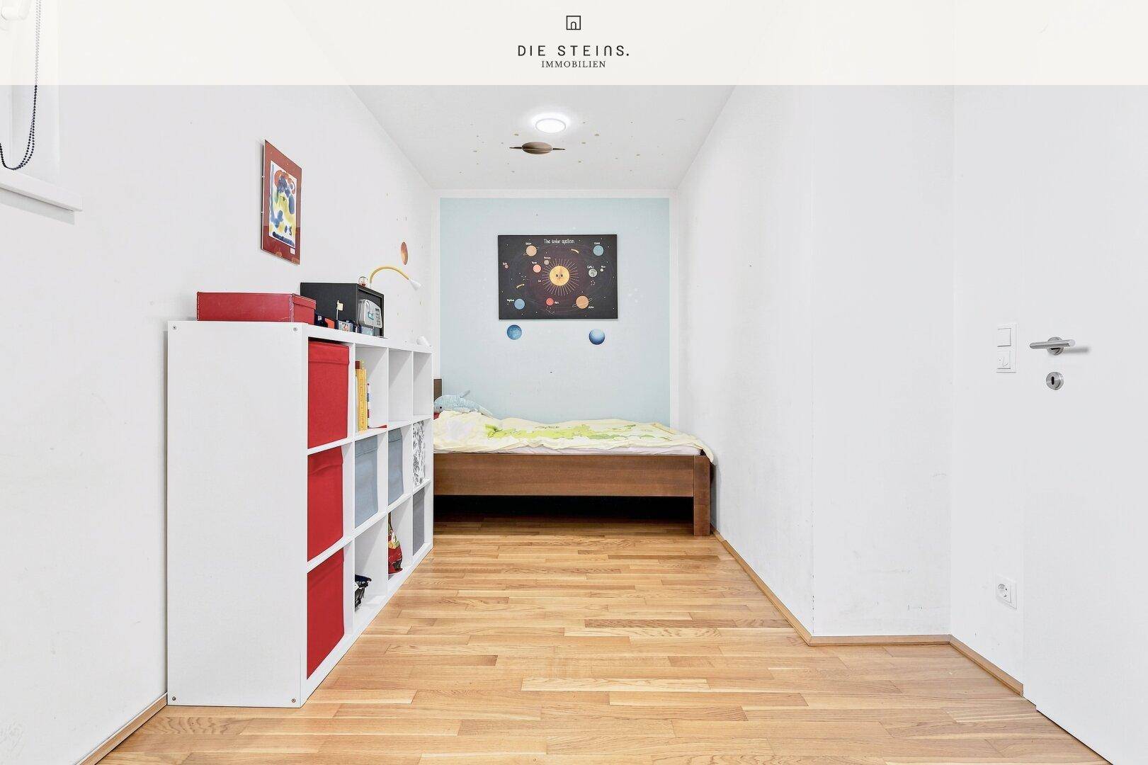 Kinderzimmer mit Holzbett, Regal und spielerischer Wanddekoration.