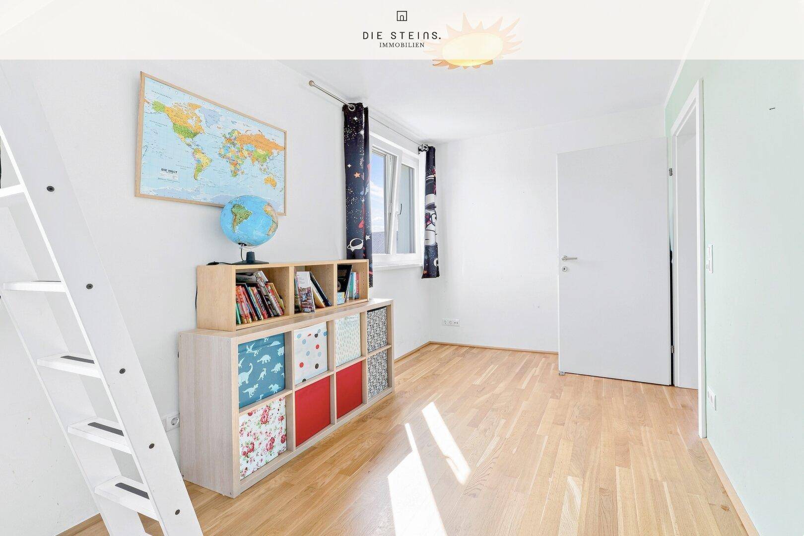 Helles Kinderzimmer mit Holzparkett, Fenster und bunten Aufbewahrungsboxen.
