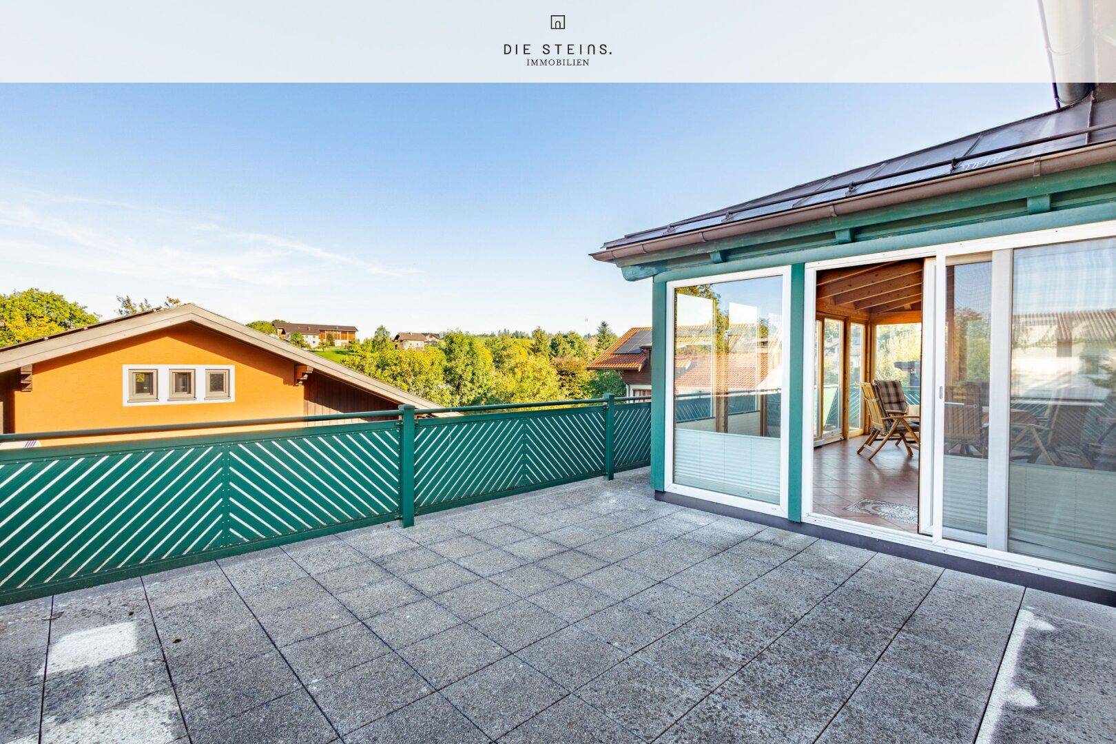Große Dachterrasse mit Fliesenboden und grüner Brüstung, angrenzend an den Wintergarten.