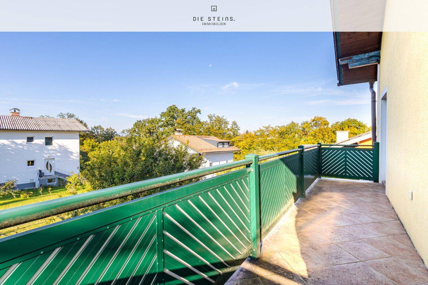 Schmaler Balkon mit grüner Brüstung und Blick auf die umliegende Landschaft.