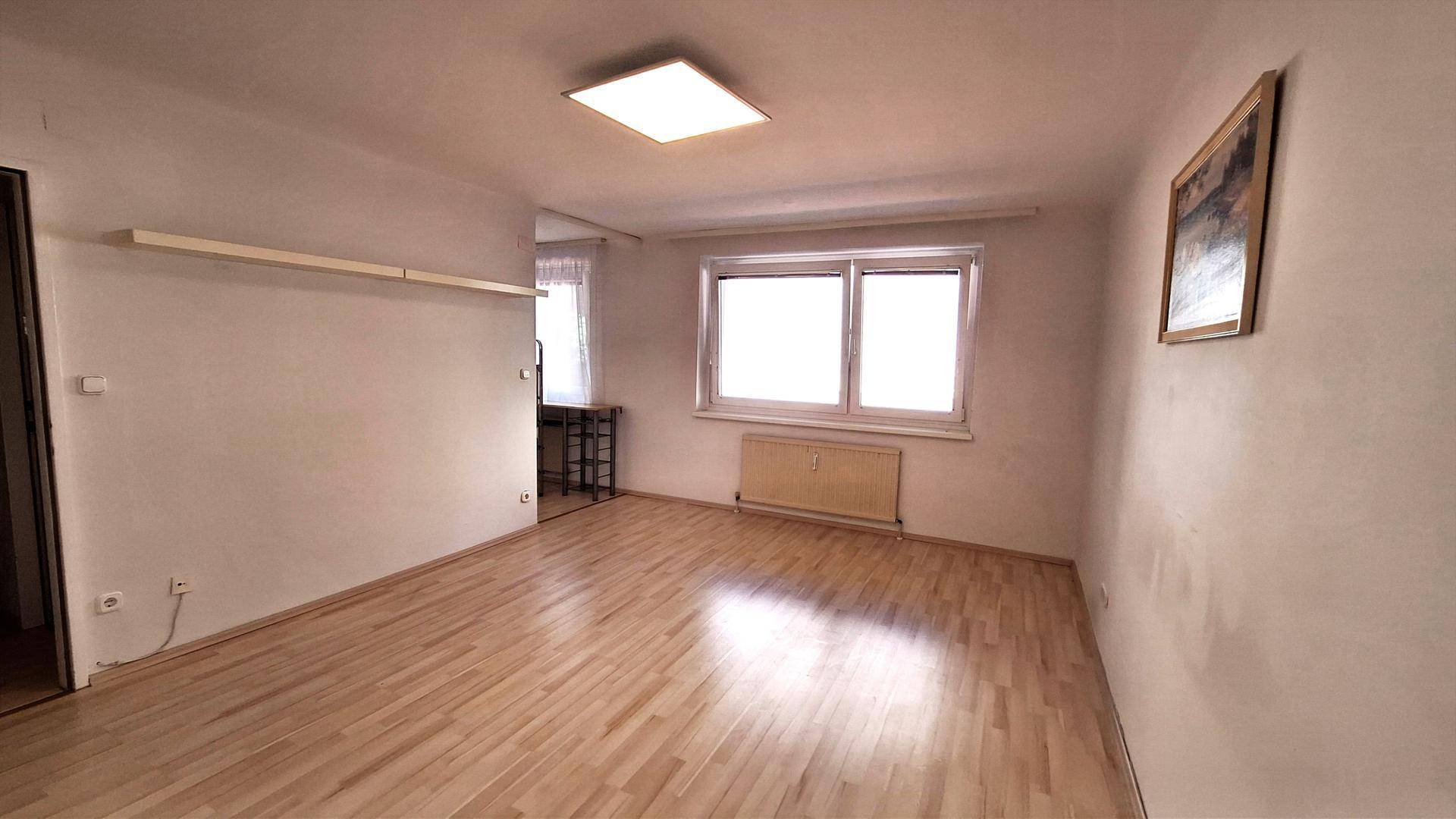Geräumiges, helles Zimmer mit Holzparkett und weißen Wänden, bereit zur individuellen Gestaltung.