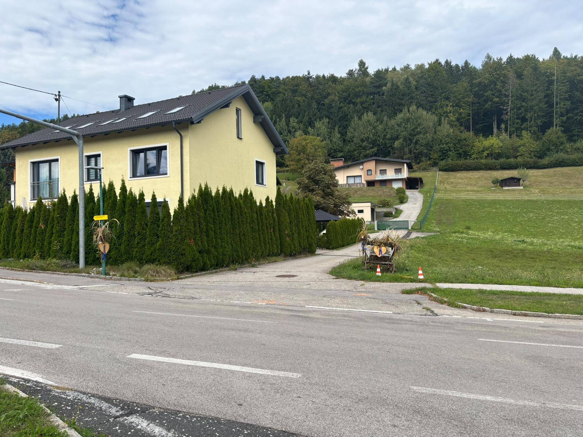 Einfamilienhaus in ländlicher Umgebung mit Blick auf bewaldete Hügel und Wiesen.