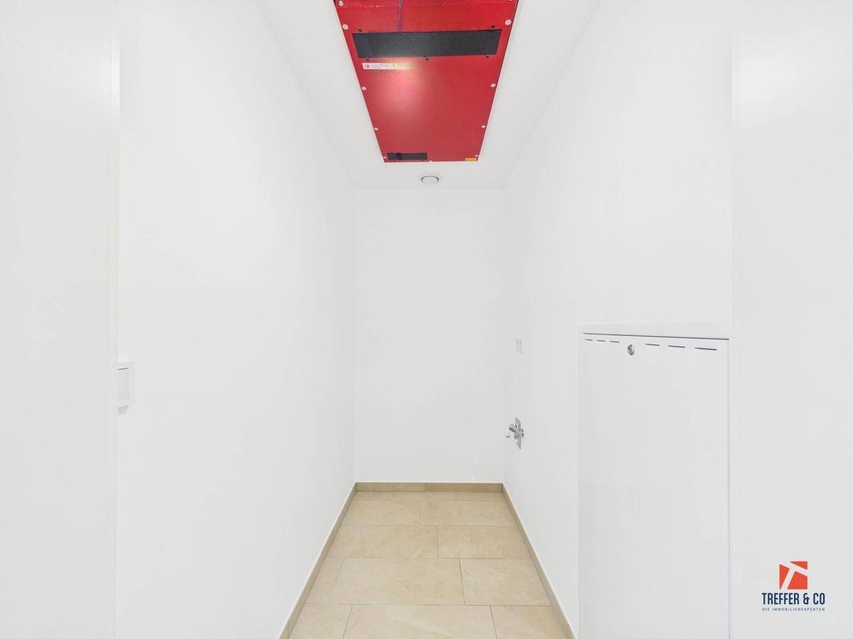 Praktischer Abstellraum mit Fliesenboden und Zugang zur Haustechnik, ideal für Lagerung.