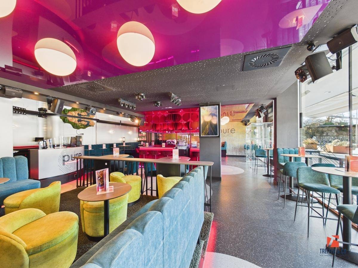 Moderner Loungebereich mit vielfältigen Sitzgelegenheiten, einer Rezeption und großen Fenstern.