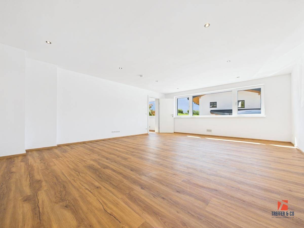 Helles, geräumiges Zimmer mit modernem Laminatboden und weitem Blick ins Grüne.