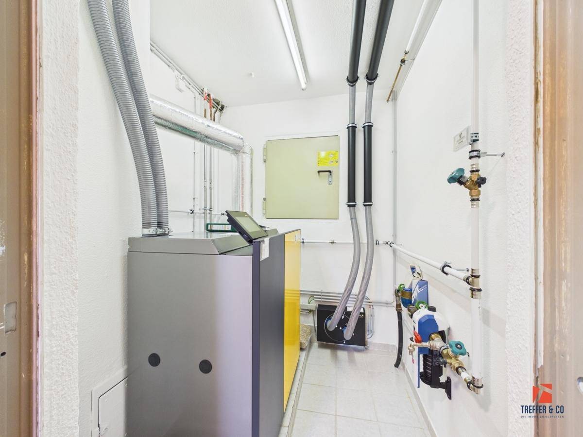 Heizungsraum mit moderner Heizanlage und sichtbaren Installationen.