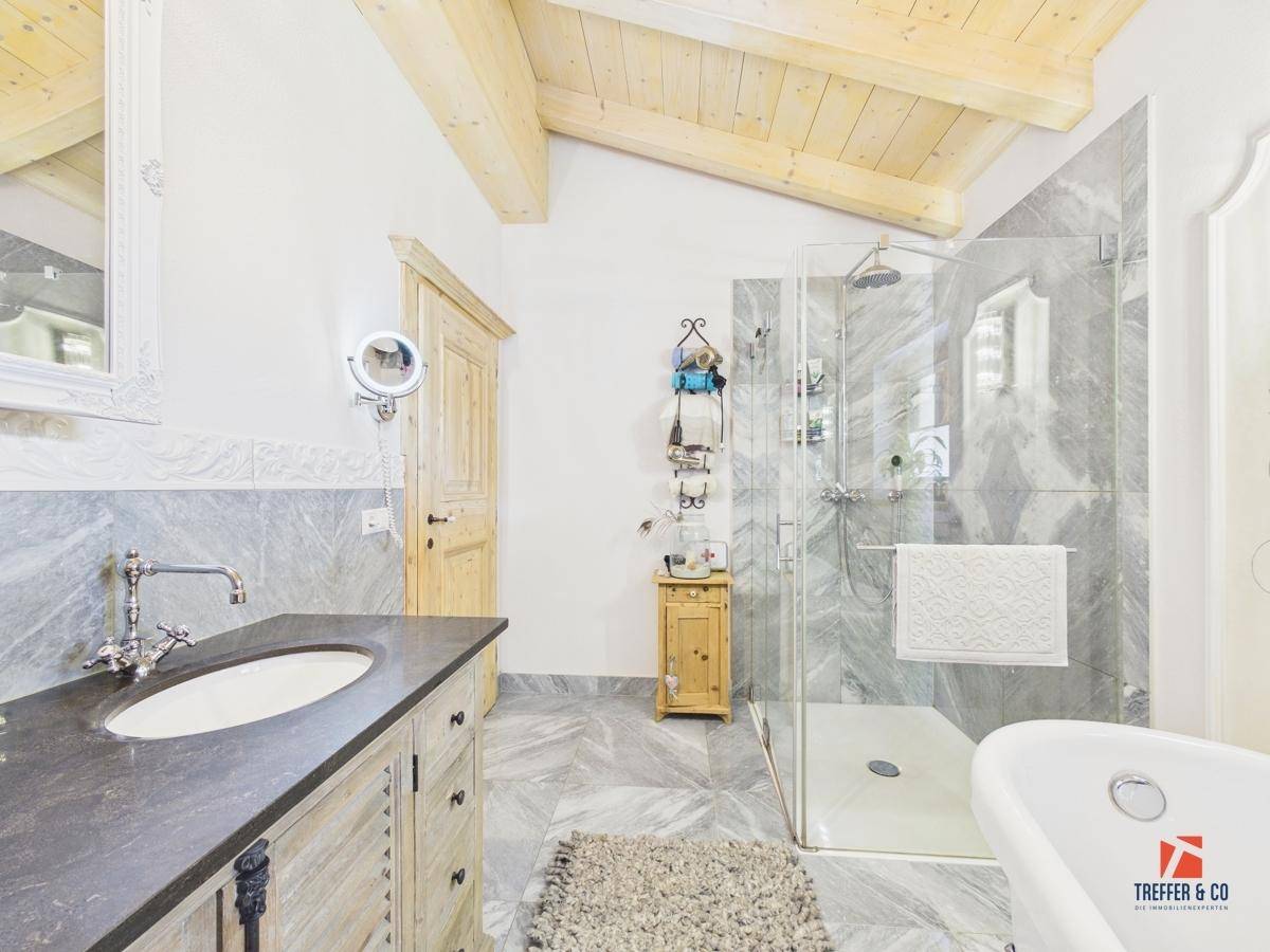 Geräumiges Badezimmer mit Einzelwaschbecken, begehbarer Dusche und freistehender Badewanne.