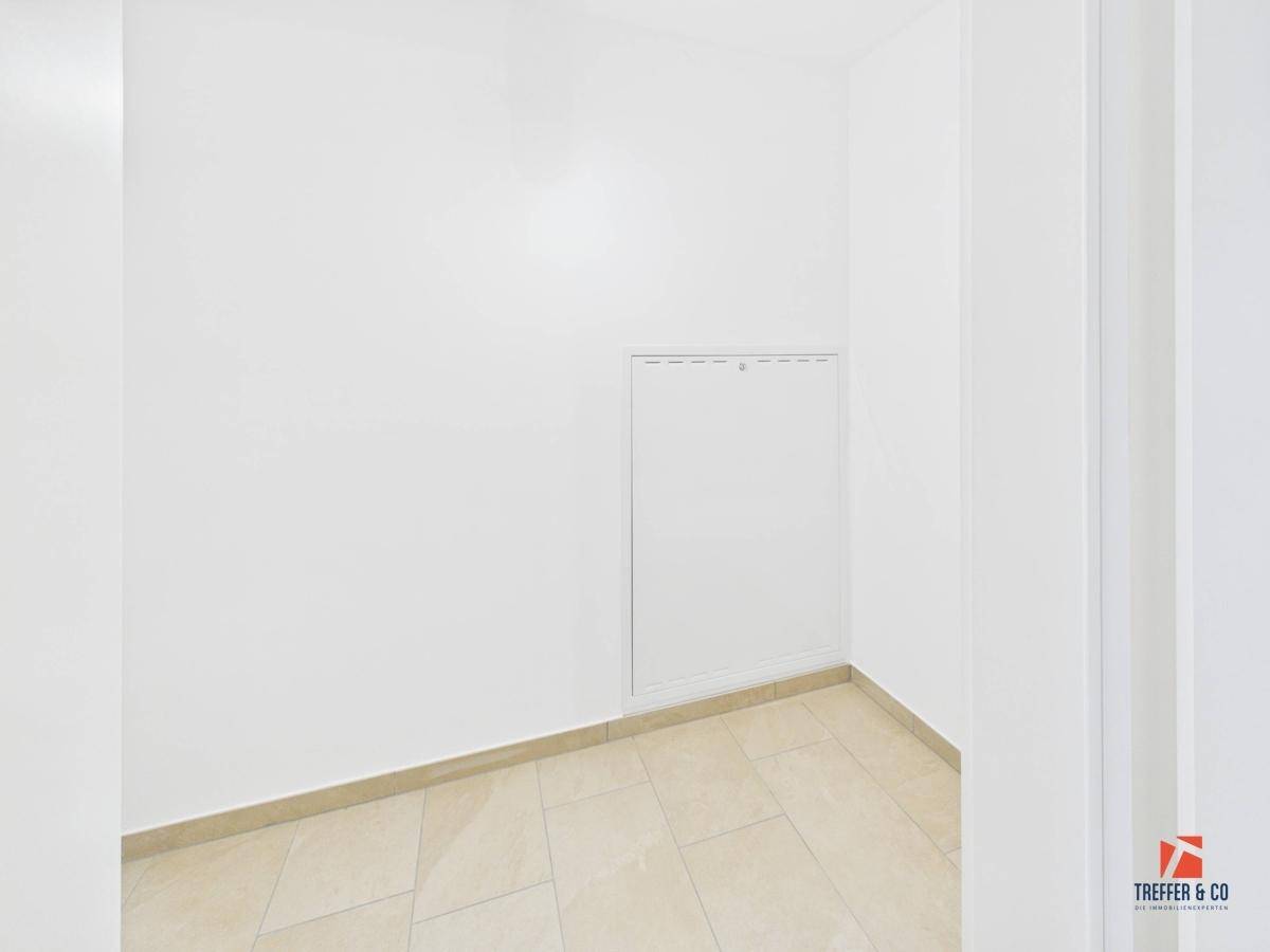 Kleiner, heller Raum mit Fliesenboden und weißen Wänden, ideal als Abstellraum.